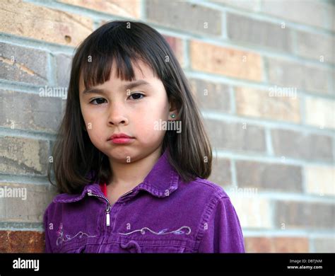 Sad Little Brunette Girl Against Brick Wall Stock Photo Alamy