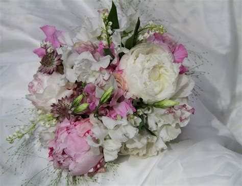 beautiful bridal bouquet in soft pinks and ivory peonies lily of the valley and sweet peas