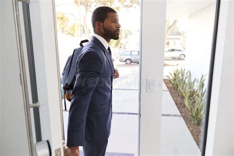 Businessman Wearing Suit Opening Door Leaving Home For Work Stock Photo