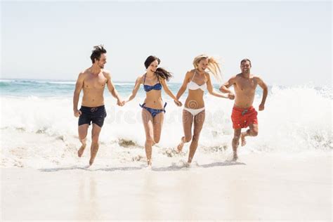 Happy Friends Holding Hands And Running On The Beach Stock Image Image Of Active Holding