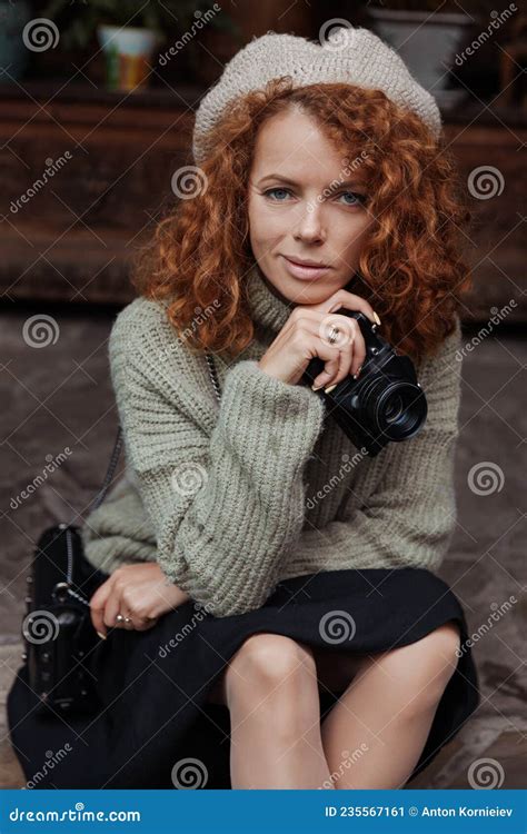 A Woman In A Beret And A Green Sweater Holds A Camera In Her Hands And Takes Shoots Stock Image