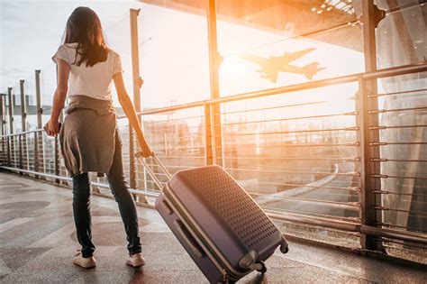 Young Woman Pulling Suitcase In Airport Terminal Copy Space Stock Photo