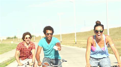 Slow Motion Of Three Young Adults Cycling Outdoors And Having Fun Taking Selfies Graded Stock
