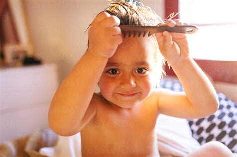 Portrait Of Little Boy Brushing His Hair After Bathing Stock Photo