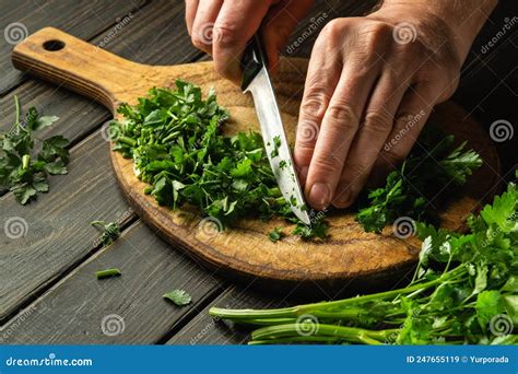 Cutting Green Parsley On A Cutting Board With A Knife For Cooking