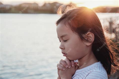 Premium Photo Multicultural Little Girl Praying With Sunflare Background