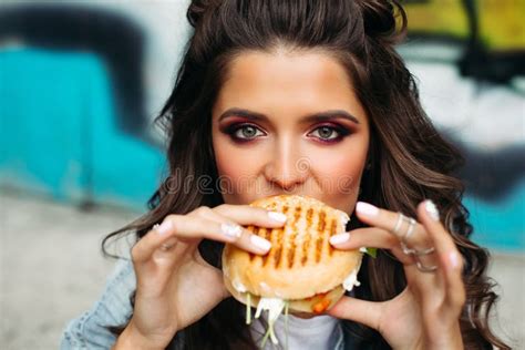 girl with bright make up taking a bite of burger stock image image of gorgeous delicious