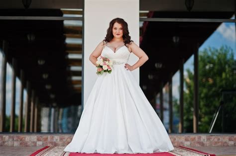premium photo big breasts brunette bride with wedding bouquet posed at wedding hall on the red