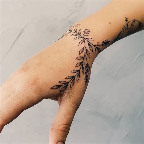 Flower Tattoo Wrapped Around The Right Wrist And Extended To The Hand