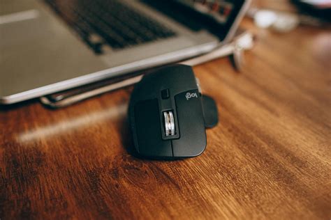 Black Wireless Computer Mouse On Brown Wooden Desk · Free Stock Photo