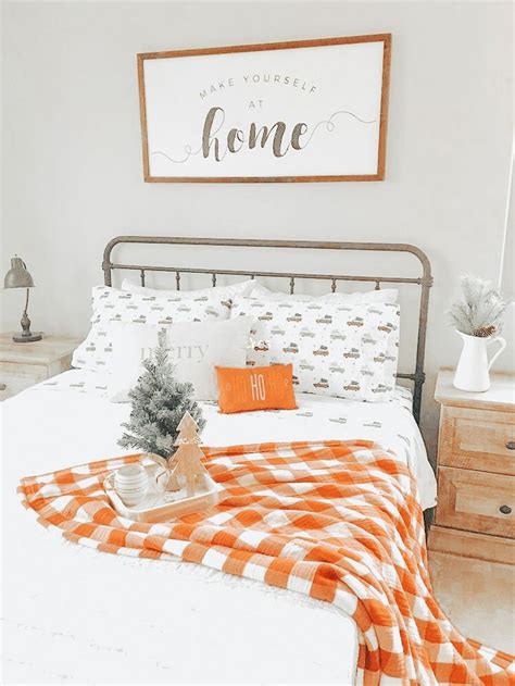 A Bed With An Orange And White Checkered Bedspread On Top Of It