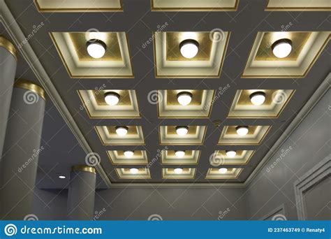 Geometric Ceiling With Square Boxes And Round Lamps In A Row And Column