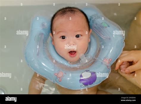 Swimming 4 Month Old Happy Baby Boy With Neck Swim Ring In Bathtub