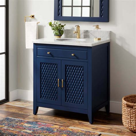 A glossy blue door opens to a dreamy blue bathroom fitted with a blue washstand donning wood and nickel pulls and a white and gray marble countertop. 30 Most Navy Blue Bathroom Vanities You Shouldn't Miss - The Architecture Designs