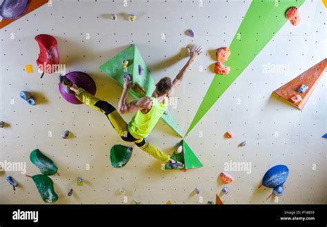 Young Man Climbing Bouldering Route Doing Splits To Reach Next