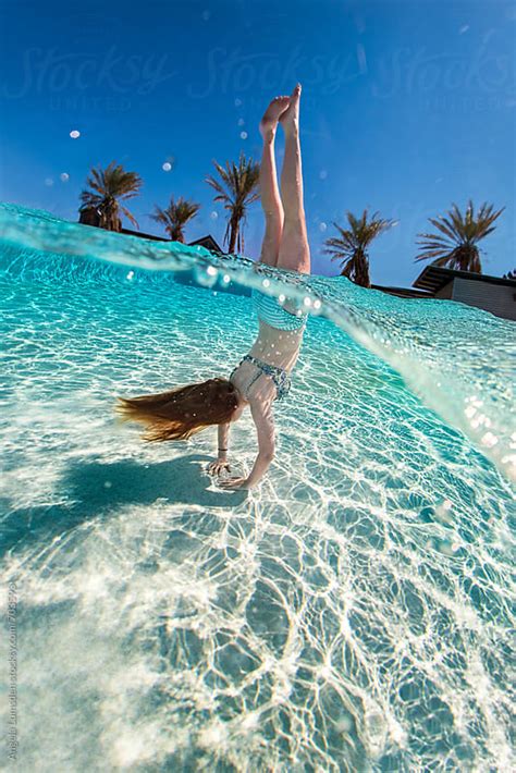 Girl In A Bikini Doing A Handstand In A Swimming Pool With An Over Water And Under Water