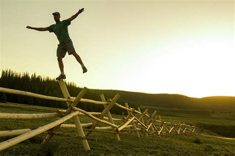 A Man Balancing On A Fence At Sunset Photograph By Kennan Harvey Fine