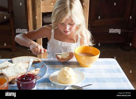 Girls Spreading Butter On Bread Stock Photo Alamy