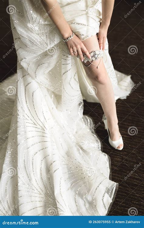 In The Morning The Bride In Stockings And A White Wedding Dress Wears A Garter On Her Leg
