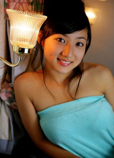 A Woman In A Blue Towel Is Holding A Light