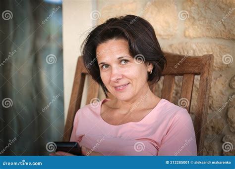Beautiful Tanned Brunette Woman Sitting With The Phone Stock Image