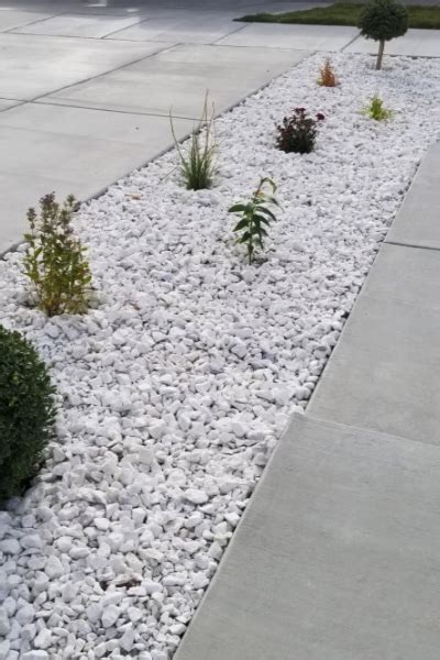 The custom iron door is a standout. 1 1/2" White Marble Stone | Landscaping with rocks, Rock landscaping ideas, Stone landscaping