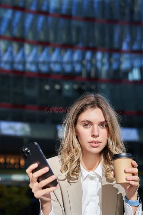 Stylish Young Corporate Woman Standing In Street Drinks Coffee And