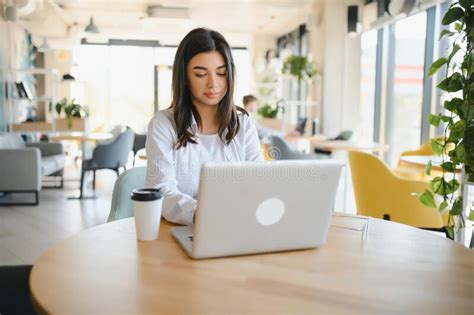 Young Charming Female Freelancer Using Laptop Computer For Distance Job