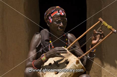 photos and pictures of pokot man playing a traditional instrument ngomongo village kenya