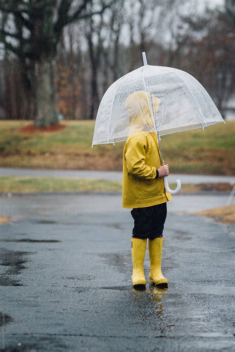 Little Boy Standing Under An Umbrella In The Rain By Stocksy