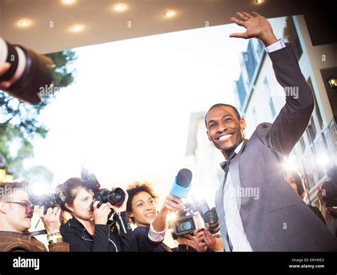 Waving Celebrity Being Interviewed And Photographed By Paparazzi At