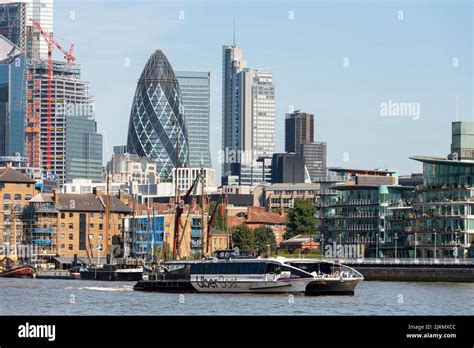 Uber Boat passing London's financial district skyline behind River