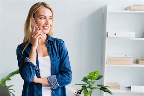 Blonde Parlant Au Téléphone Au Bureau Photo Gratuite