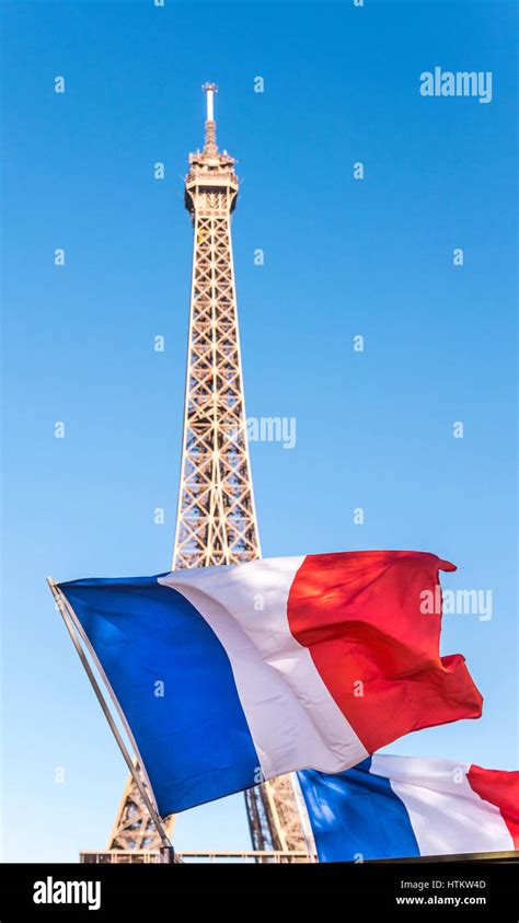 A French Flag Flies In Front Of The Eiffel Tower In Paris France On A