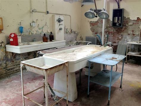 An Old Room With Two Sinks And Several Other Items On The Floor