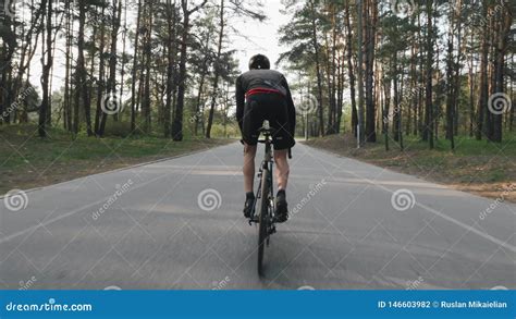 Strong Cyclist Riding A Bicycle Out Of The Saddle Cyclist With Strong Leg Muscles Pedaling