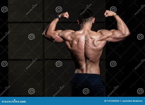 Muscular Man Flexing Muscles Rear Double Biceps Pose Stock Photo