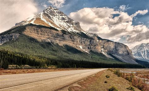 Concrete Road And Mountain Under Blue Sky And White Clouds Photo