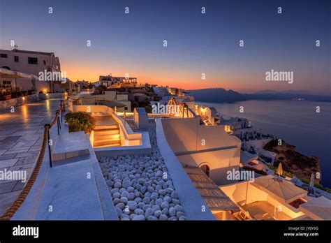 The Dusk Lights Illuminate The Typical Greek Village Of Oia Santorini