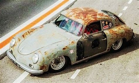 An Old Rusty Car Is Parked On The Side Of The Road