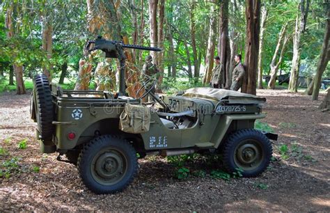 Second World War Jeep With Machine Gun Parked In Woods With Men Dressed