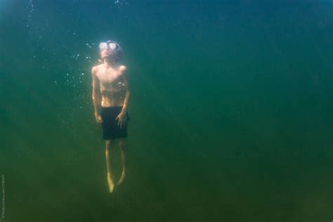 Little Boy Swimming To Surface In Deep Green Freshwater Lake By Jp