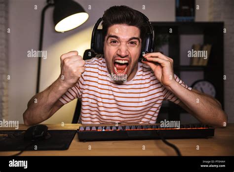 Screaming Angry Gamer Playing Video Games On Computer While Sitting By