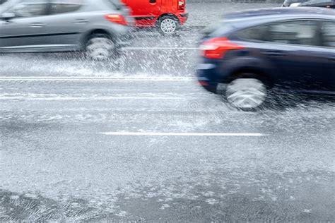 Blurred Car Driving On Wet Road With Puddles And Splashes Stock Image