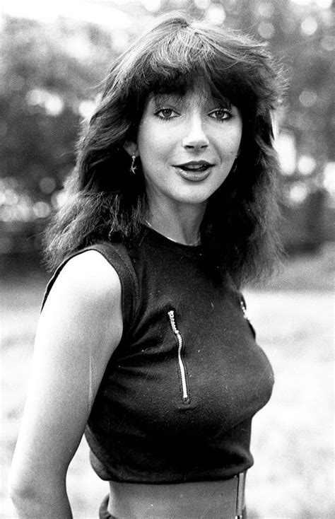 a black and white photo of a woman with long hair wearing a cropped top