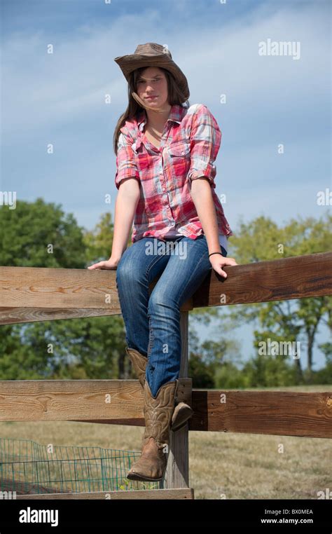 Country Girl Teenager Sitting On Rail Fence In Casual Dress Cowboy Hat