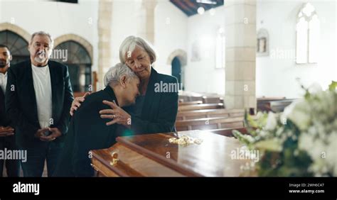 Senior women, hug and funeral in church for comfort, support and care