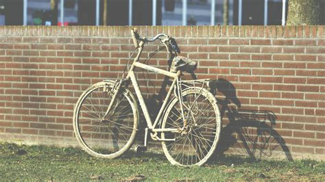 White Cruiser Bicycle Parked Beside Brown Building · Free Stock Photo
