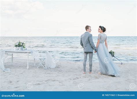 Newly Married Couple Holding Hands By The Sea Stock Photo Image Of