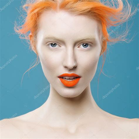 Porträt von schönen Mädchen mit orangen Haaren auf blauem Hintergrund ...